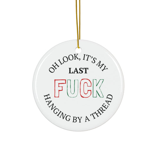 Round white ceramic ornament with humorous text design on a white background