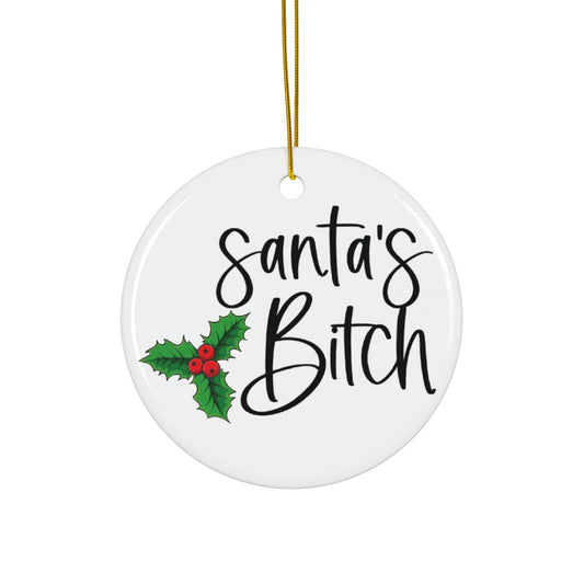 Round white ceramic ornament with 'Santa's Bitch' text and holly design on a white background